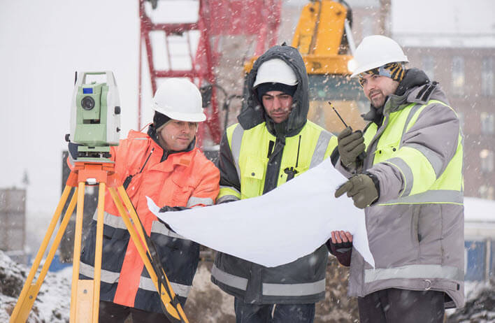 3 civil engineers looking at blueprints