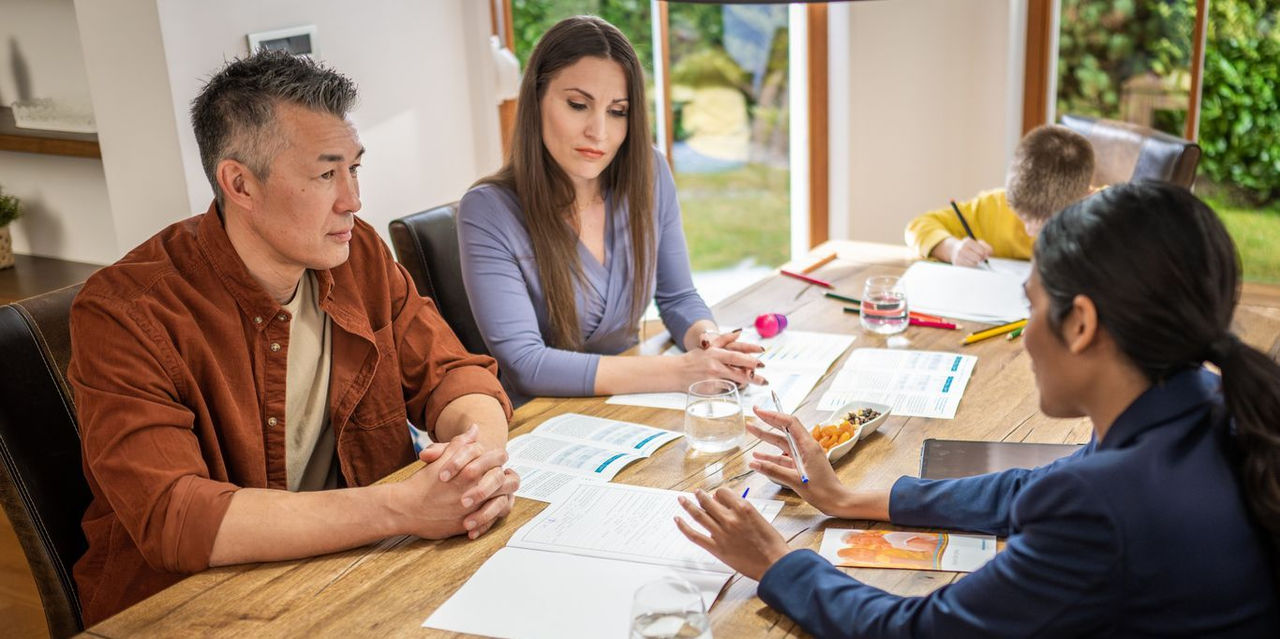 Real estate agent explaining house leasing agreement to mid adult couple