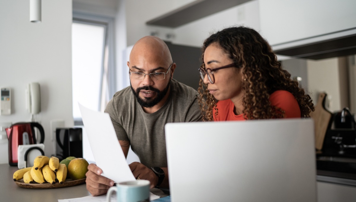 African-American couple in their kitchen looking at their investments