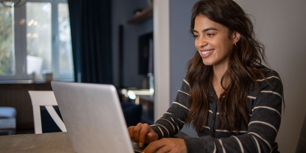 Young adult Latina on her laptop learning about the bond market