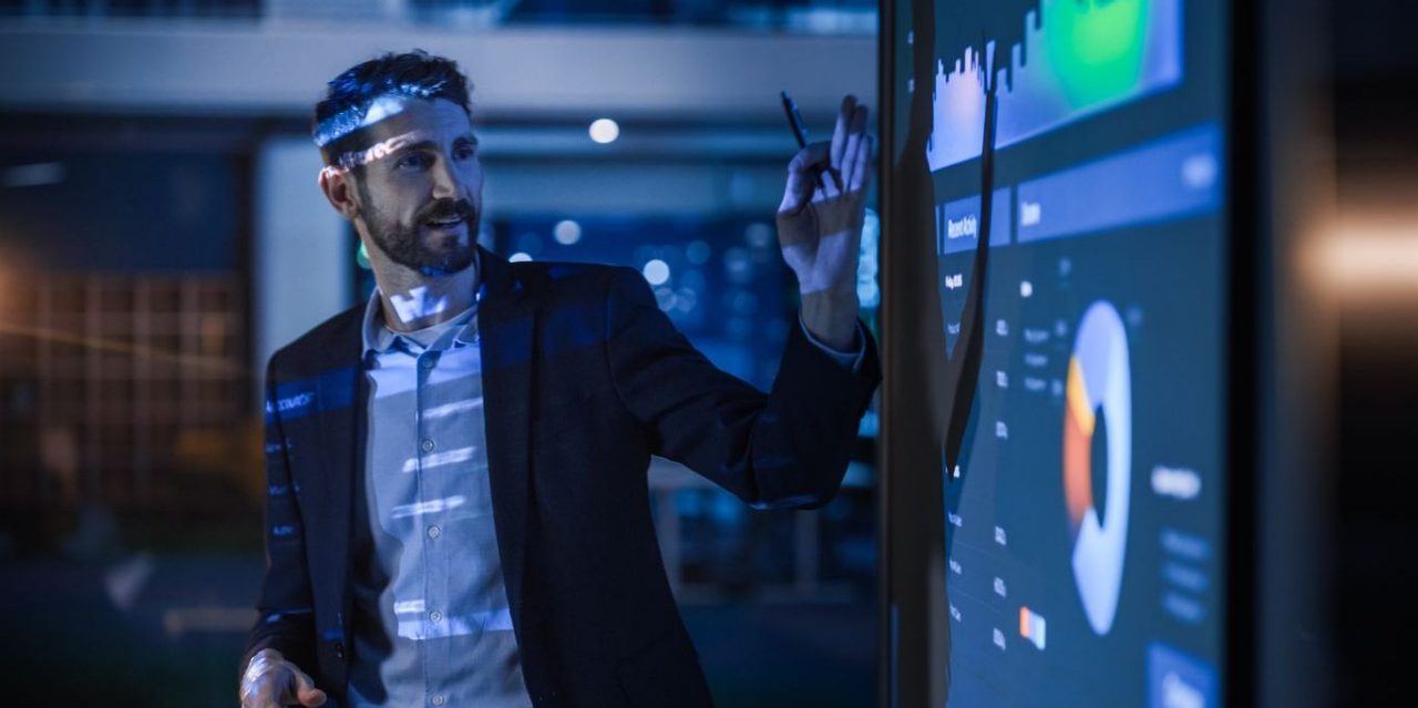 Financial professional presents market performance data on a screen