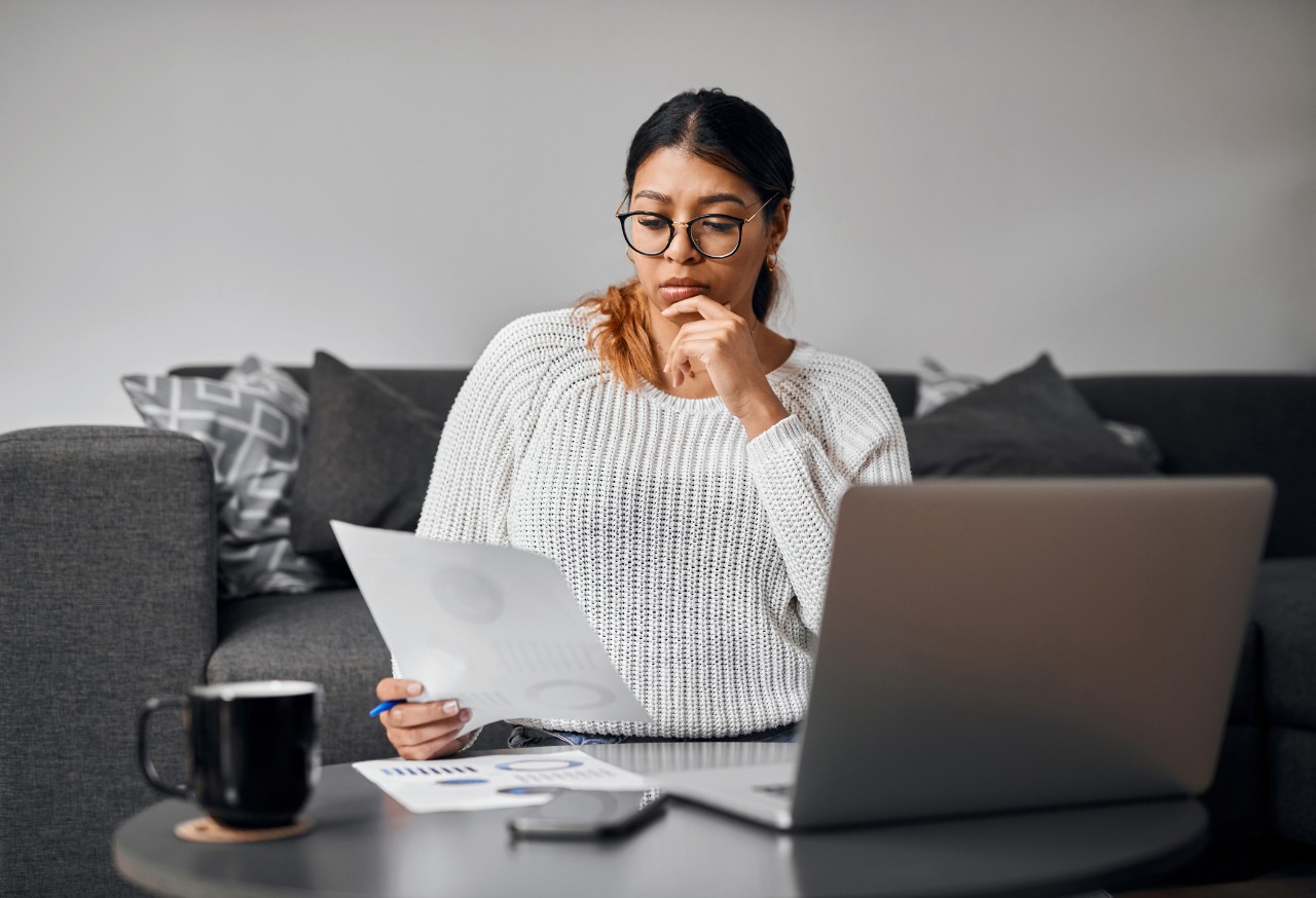 Woman in living room analyzing investment documents