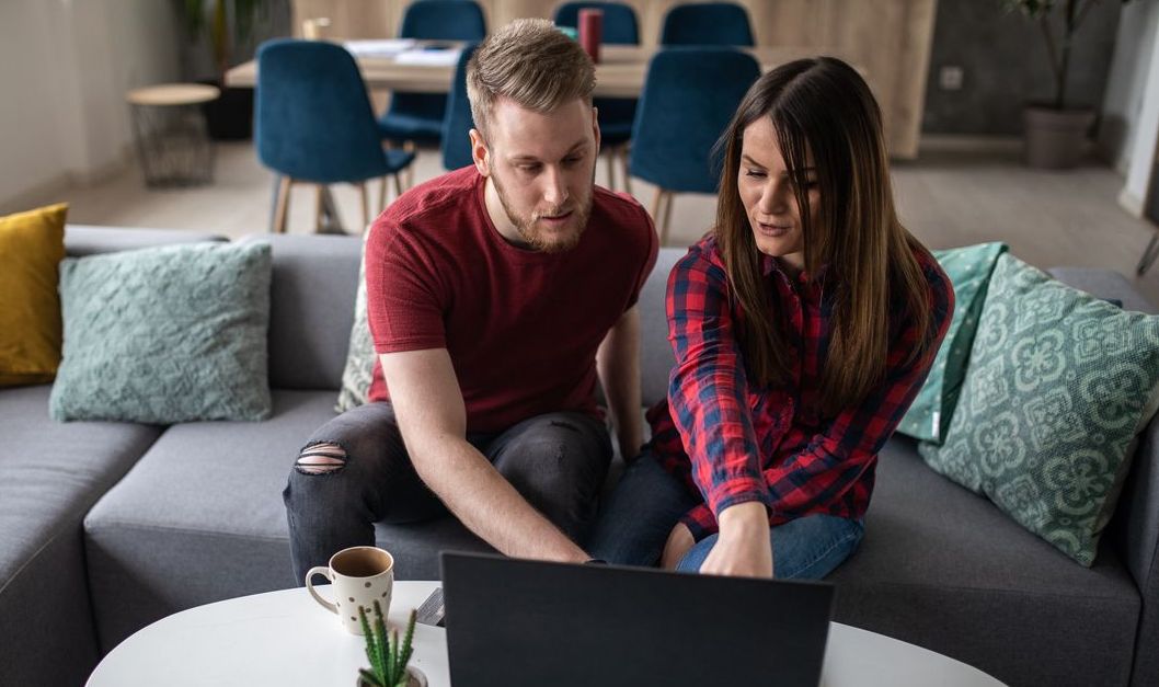 Young couple at home using a laptop to learn more about mutual funds