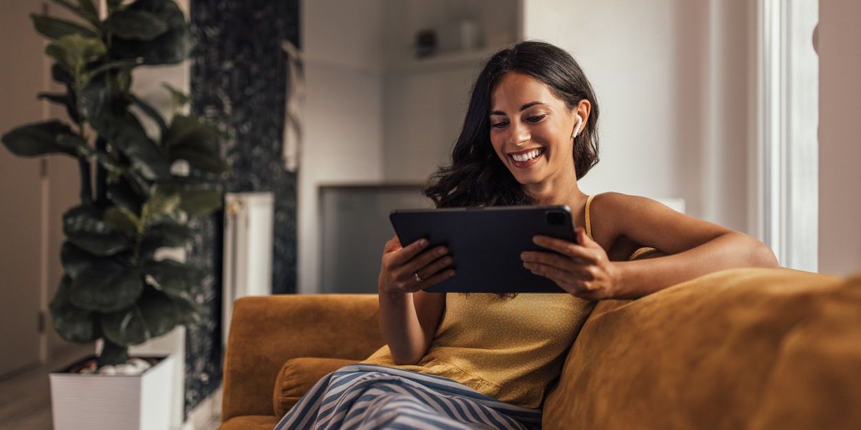 Adult woman, having a video call with her friends, on her tablet.