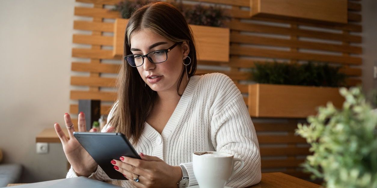 Young female studying her tablet in a coffee shop