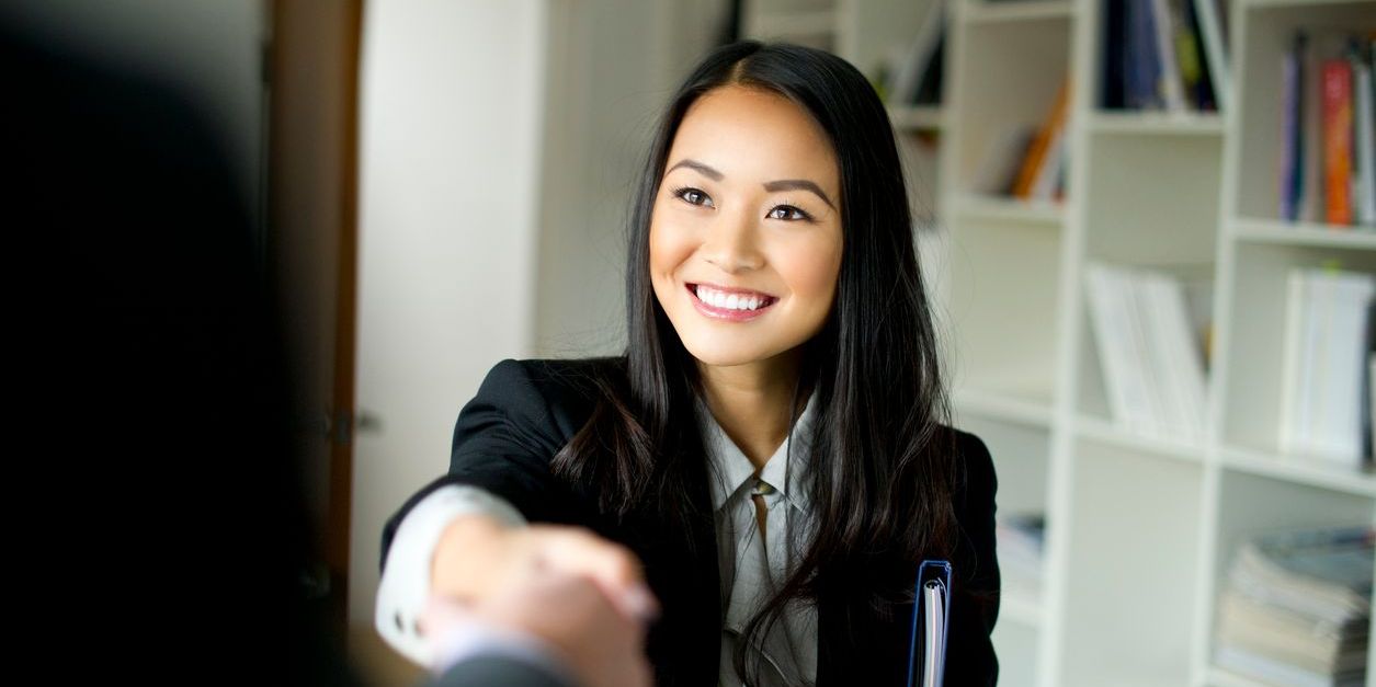 Female Asian professional greeting a new coworker