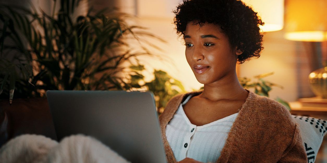 Shot of a young woman using her laptop while sitting at home