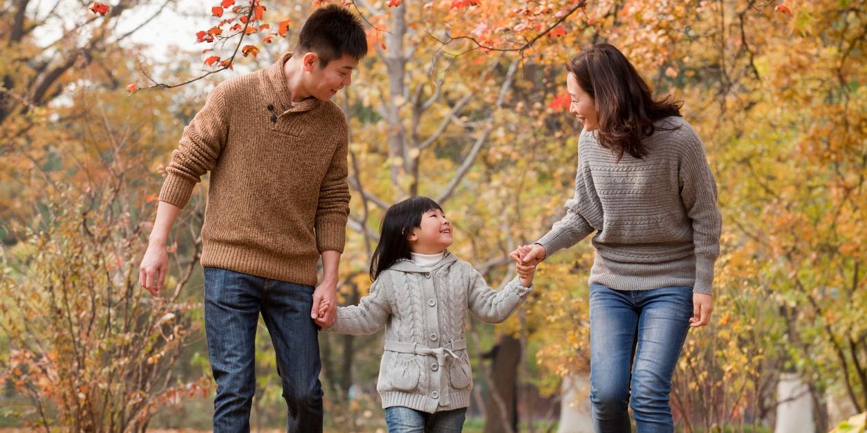 Family walking through the park in the autumn