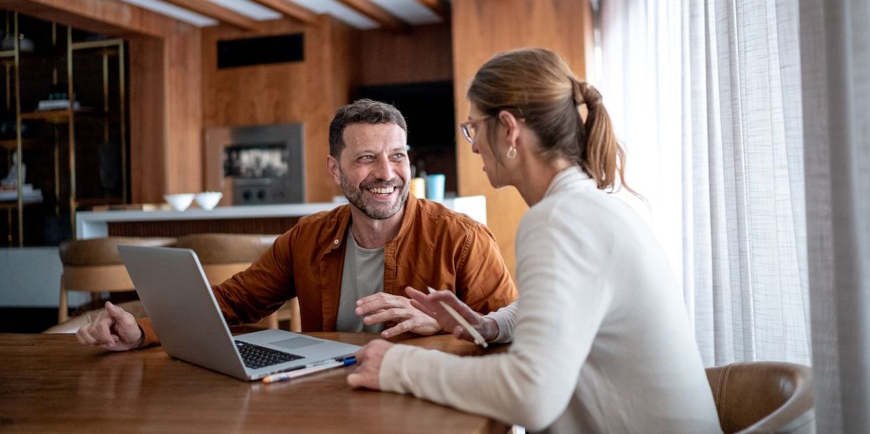 Mature couple talking and using the laptop at home