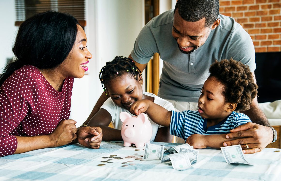 African American family using a piggy bank to learn how to save money.